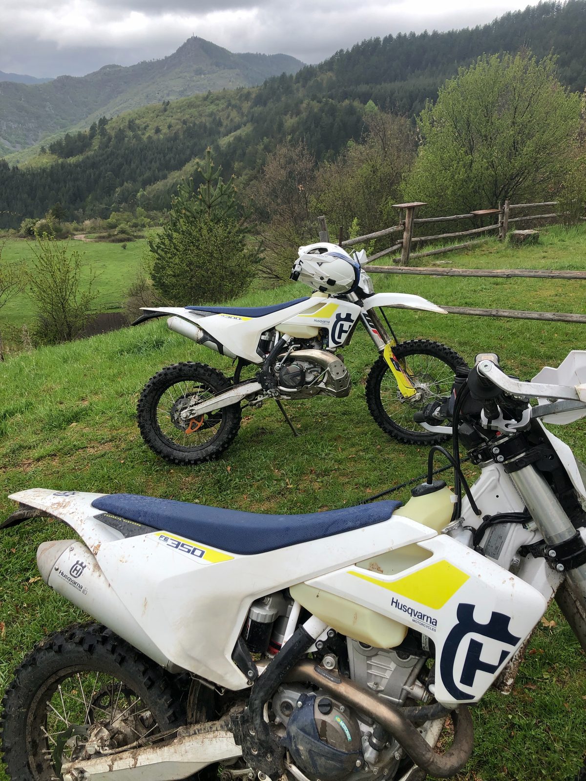A Husqvarna TE300 and FE350 having a quiet lie-down on the hillside. They earned it